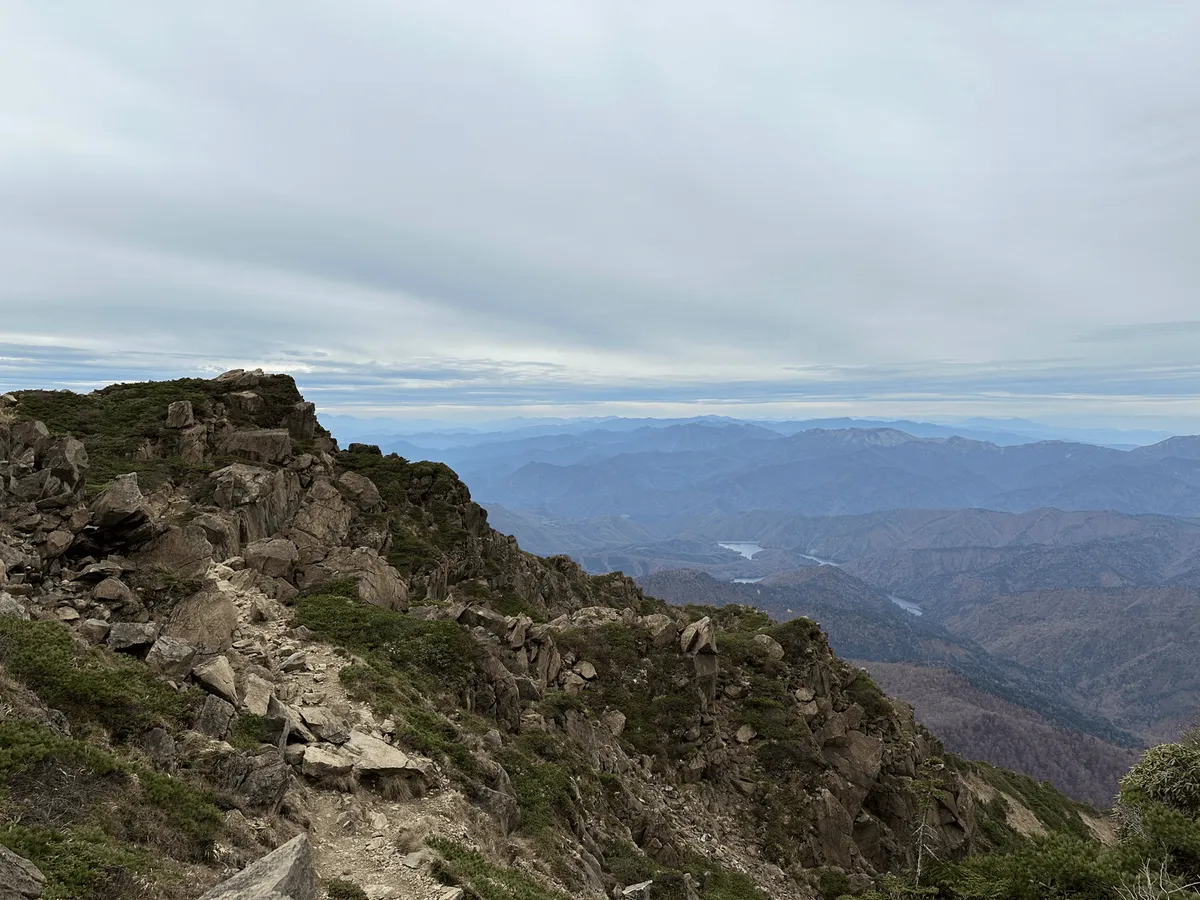 Descent trail on the left, view out to the forests below on the right