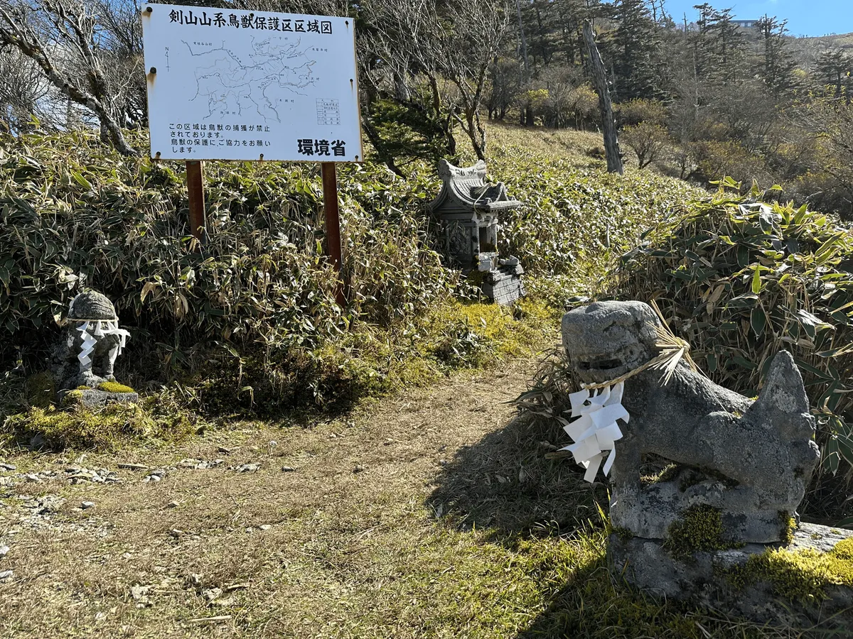 Small stone dog-like statues guarding the trail.