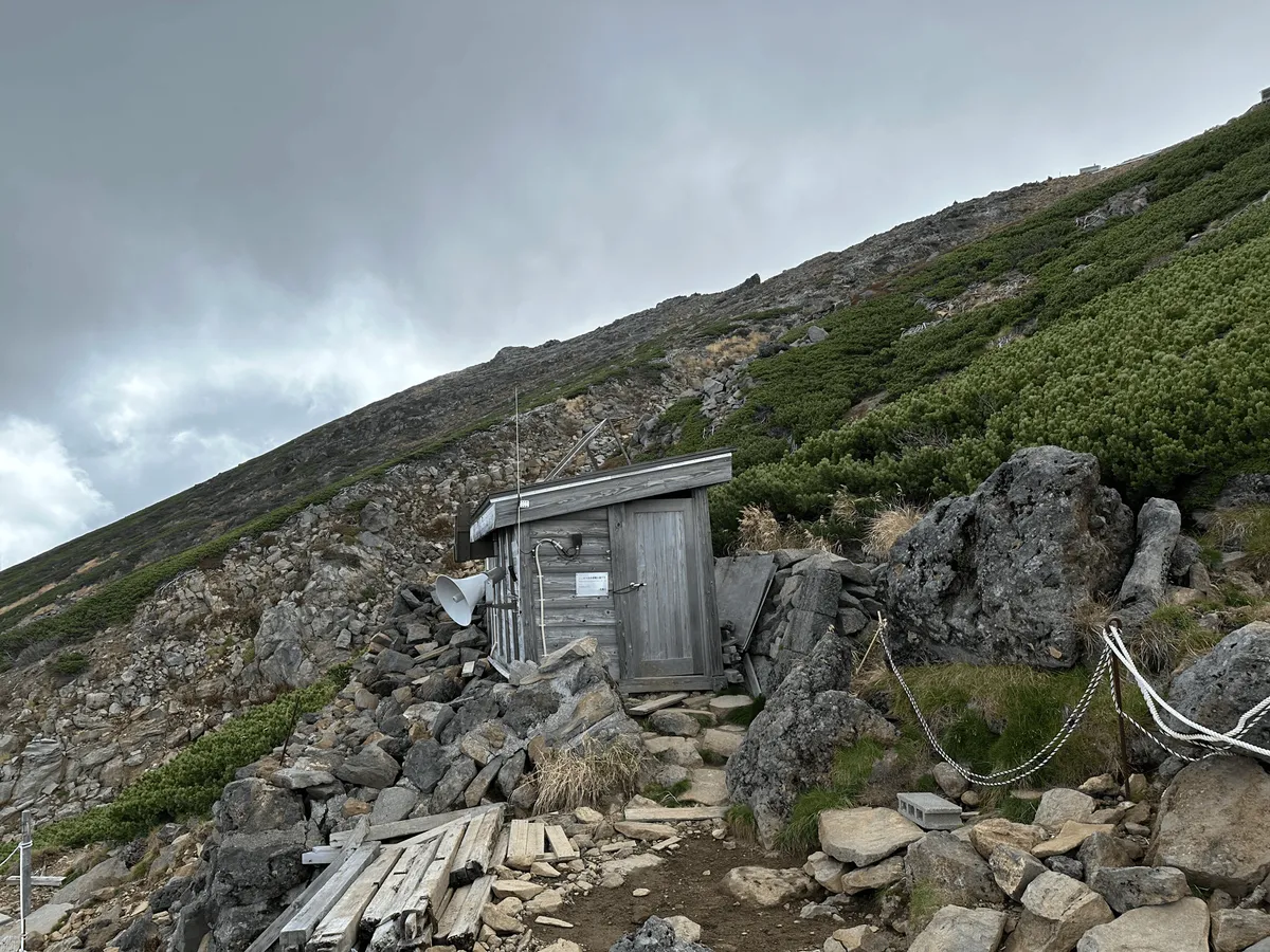 A small wooden building, the door is closed.