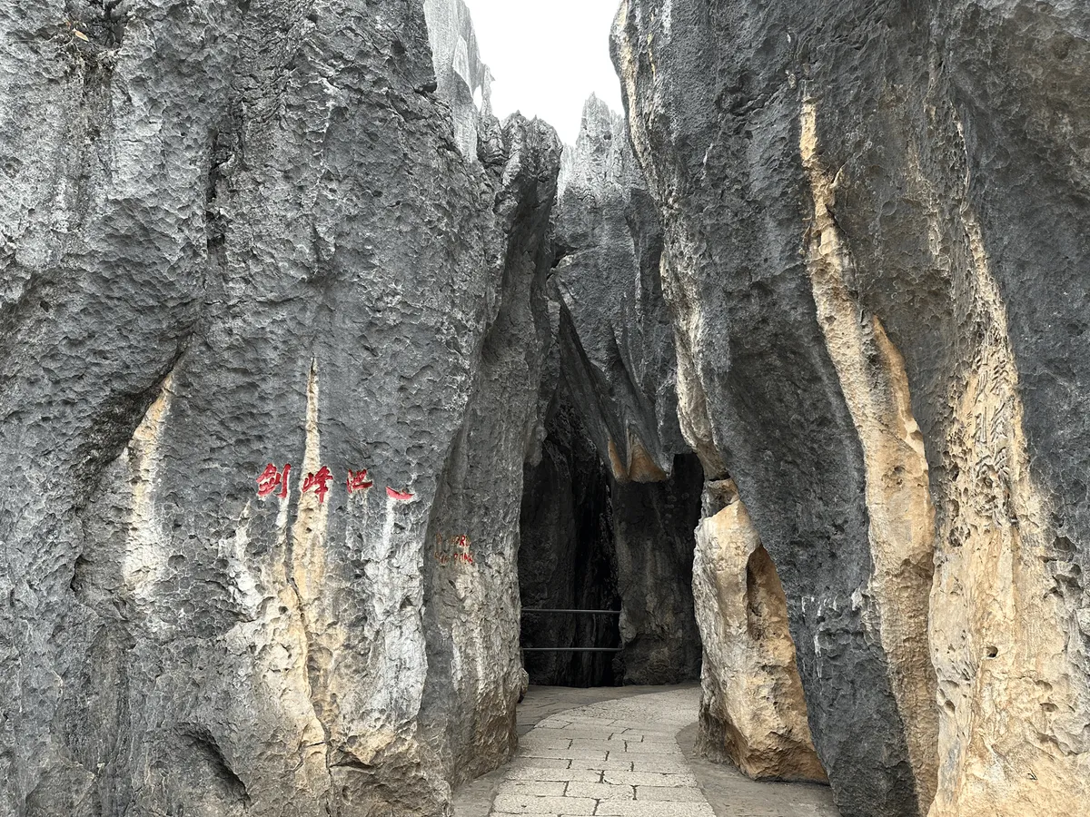 Rock wall with painted directional signs pointing to Sword Lake