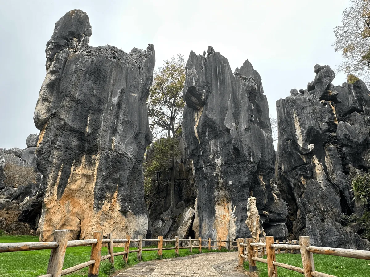 A grassy path winding through tall limestone formations