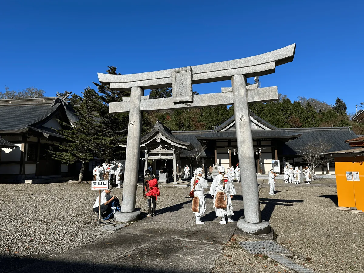 A smaller Torii gate, with shugendo practitioners dressed in white.