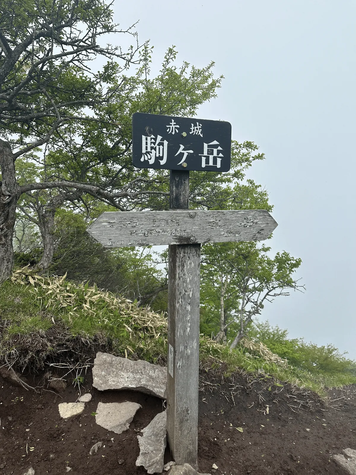 A black sign marking the peak of Mt Komagatake