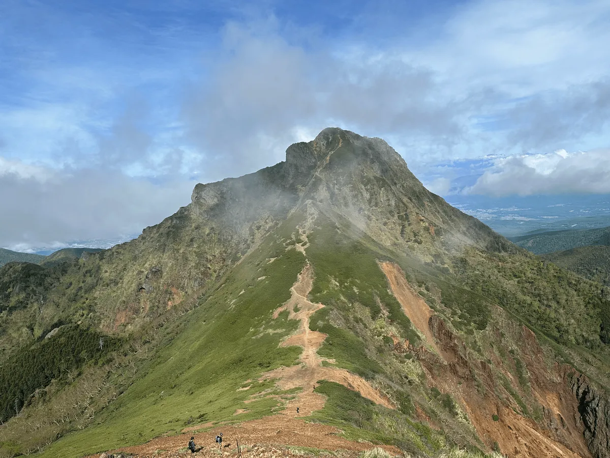 Mt Amida is green, with a long brown trail running its way up its back