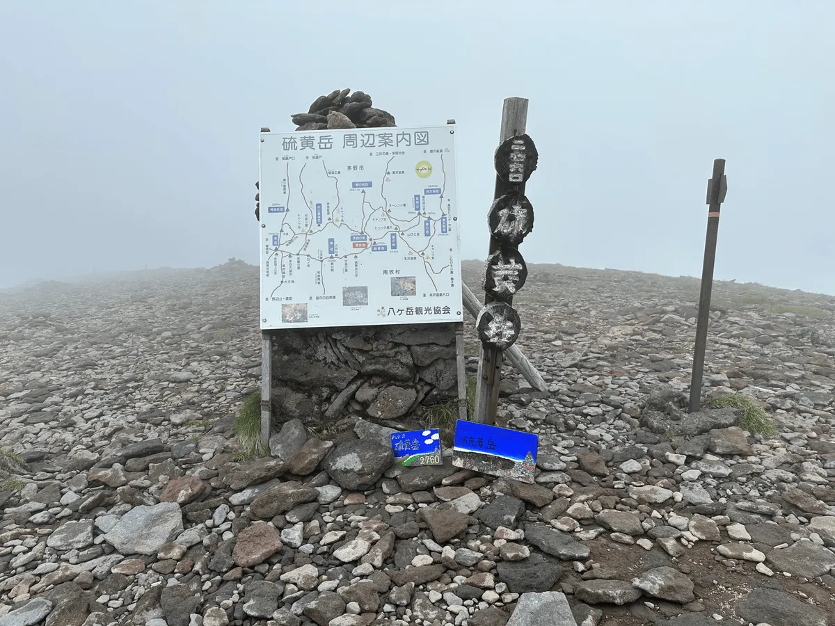 Mt Io's summit marker. The summit has a lot of flat pebbles. It's very foggy.