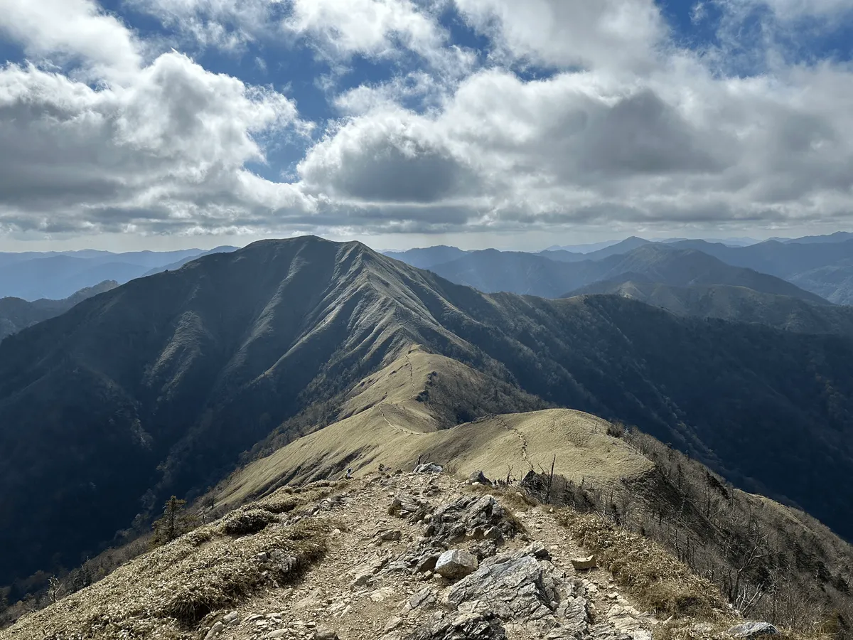 The green mountain stretches out before us, with a little trail etched in the top of it.