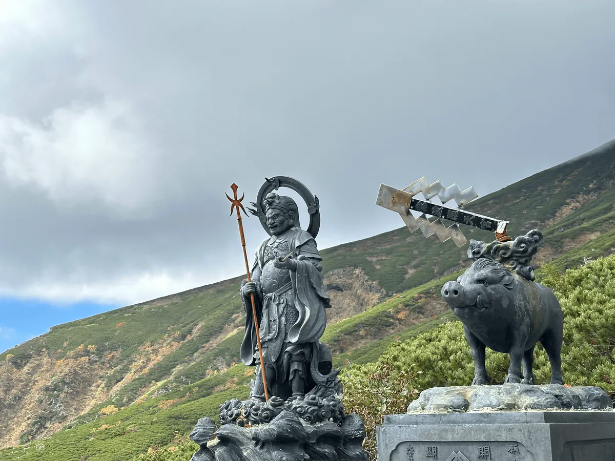 Two statues of deities and one of a pig in the middle.