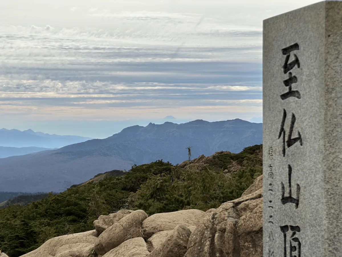 A closeup of the peak marker with Mt Fuji visible in the background