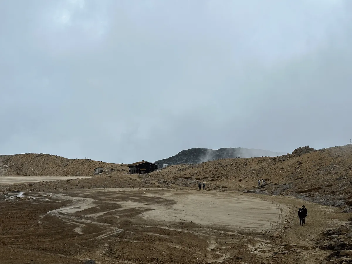 The Ninoike hut visible in the distance, with some people walking in the foreground.