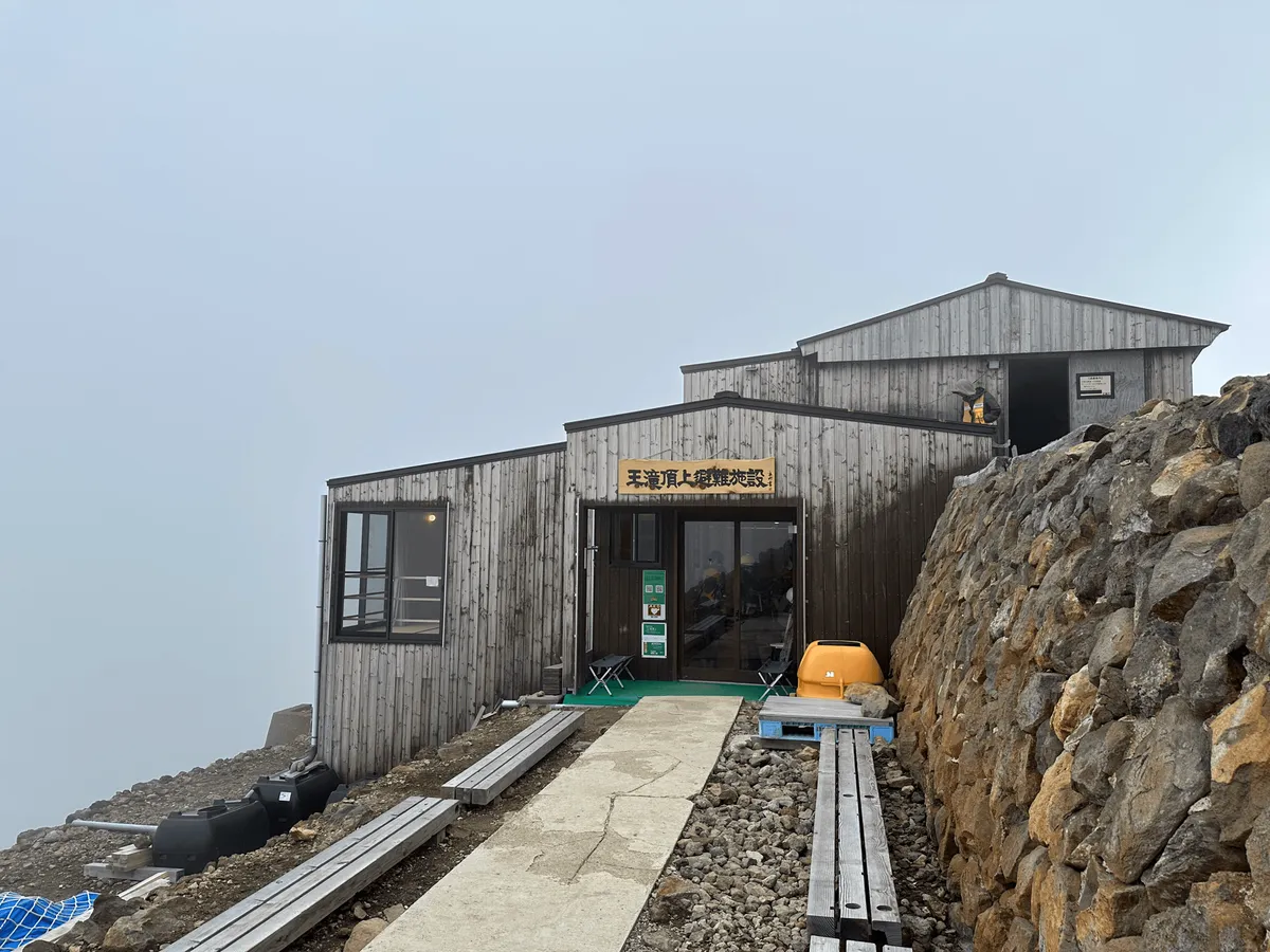 A wooden building on the side of the mountain.