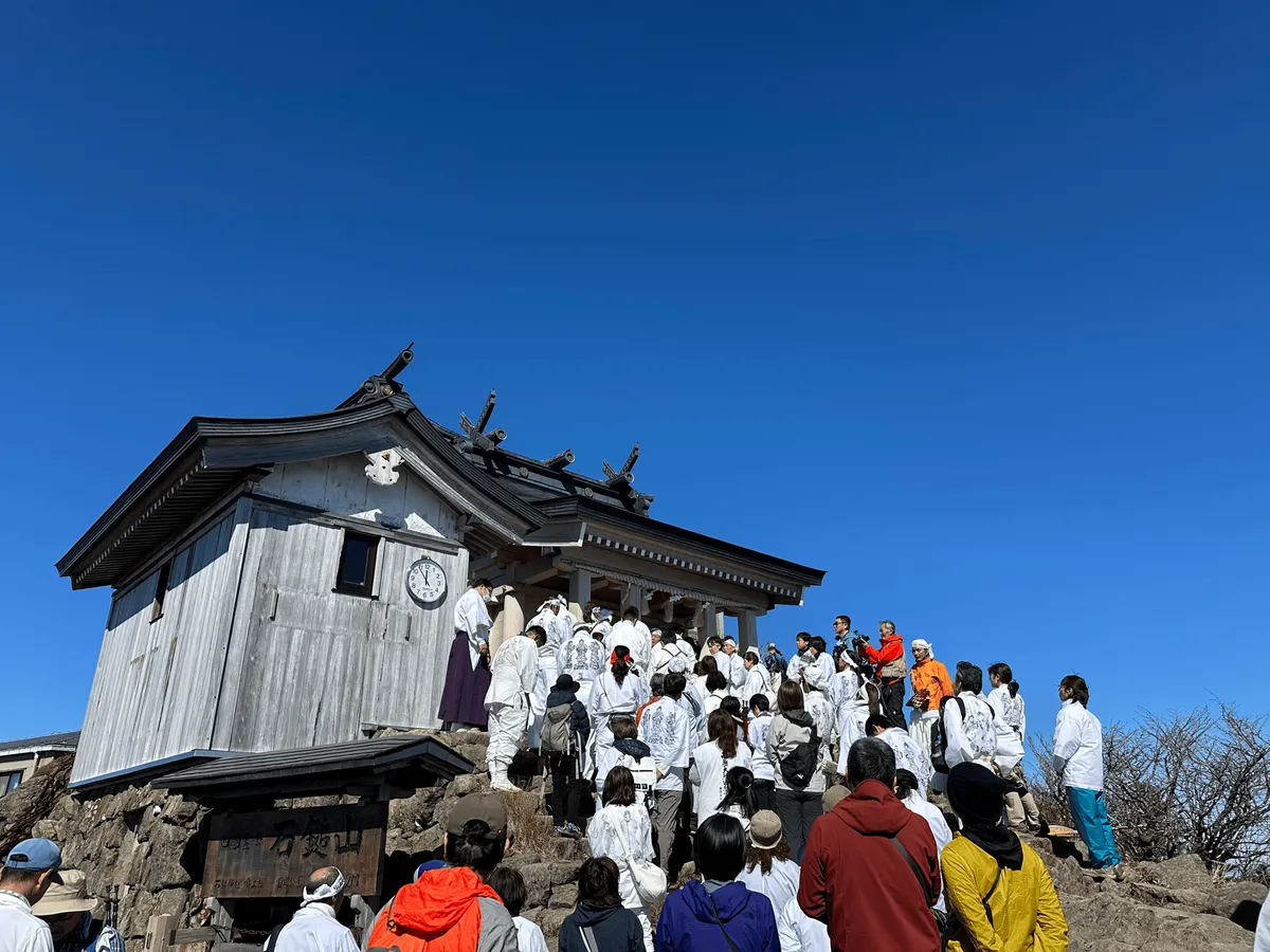 Lots of people dressed in white at the summit shrine