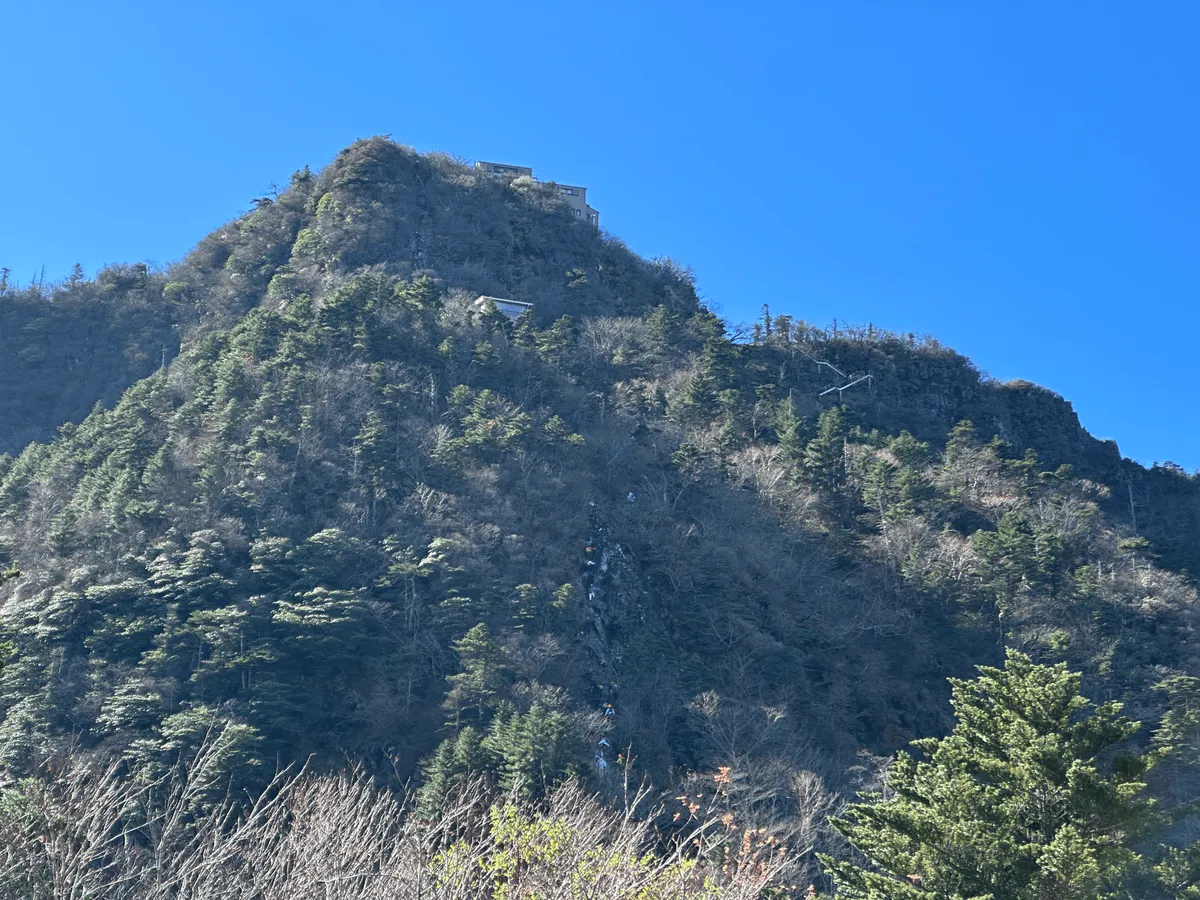 A long line of people climbing the side of the mountain in the distance