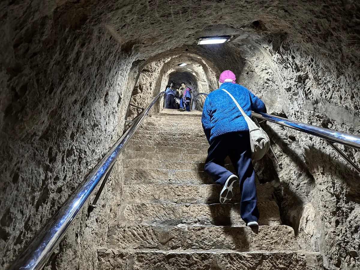 A steep tunnel carved through the rock with stairs