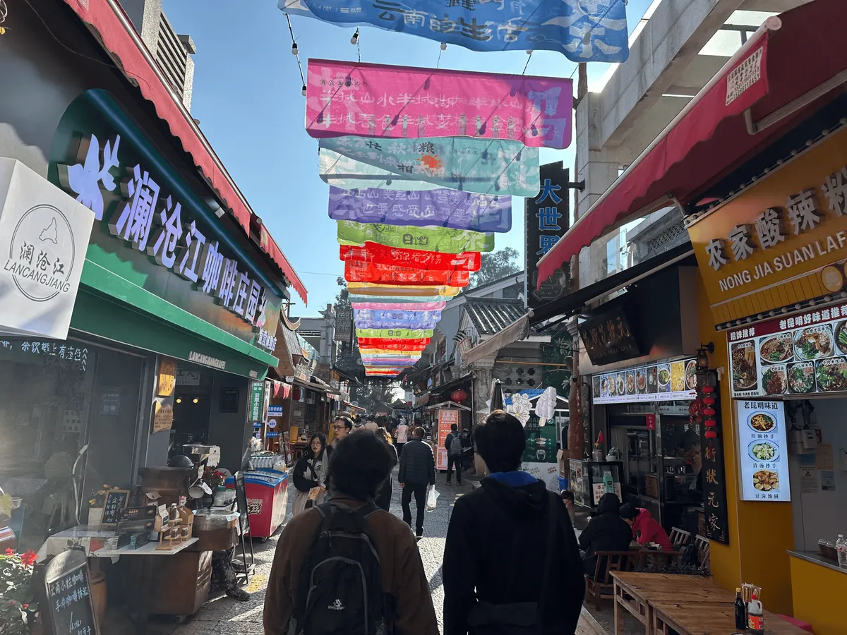 People walking along a street with stores on either side.