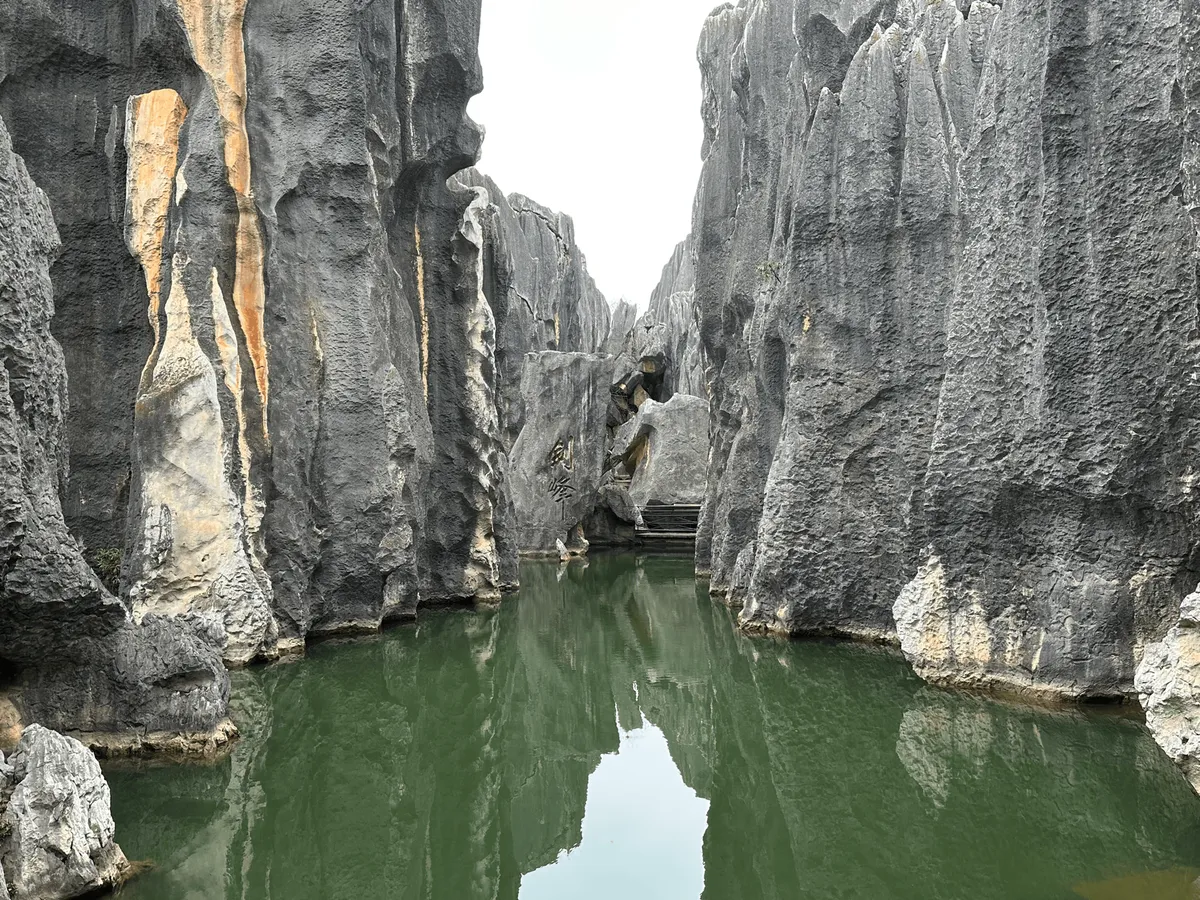 A serene pond surrounded by tall limestone formations