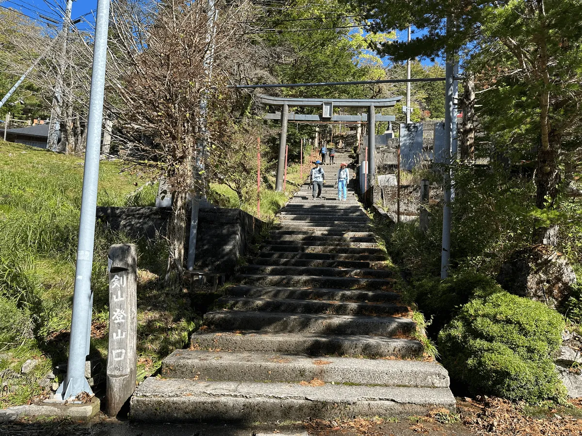 Large wooden torii gate with stairs in between.